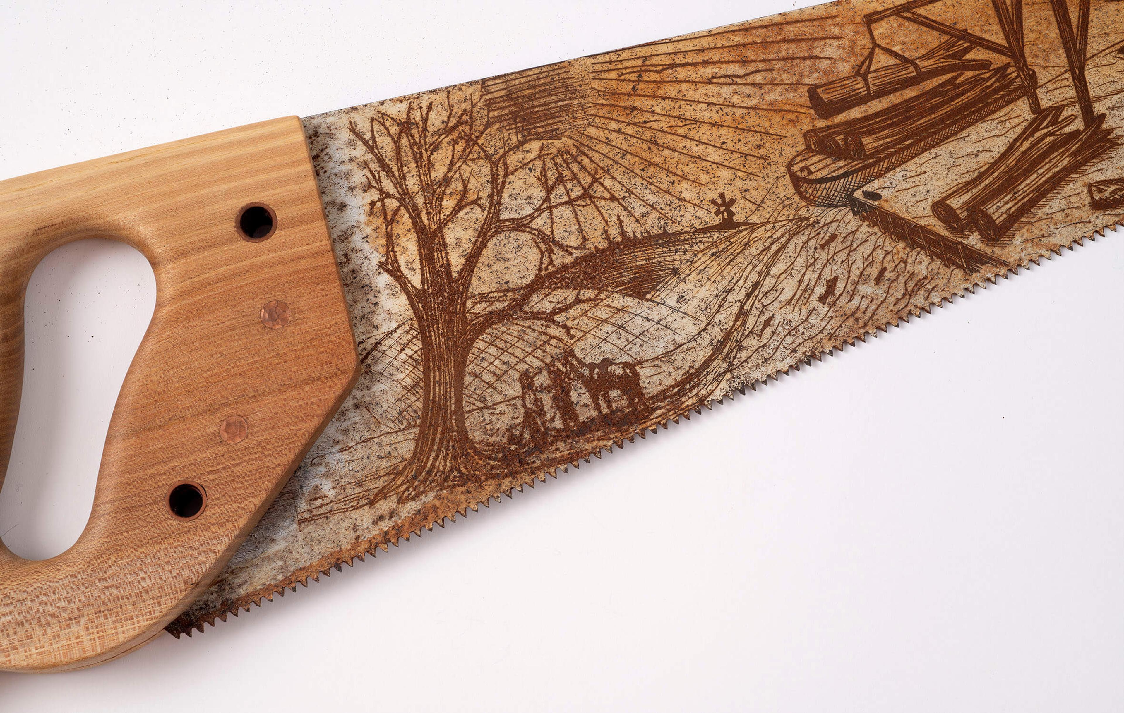 A close up of a saw with an illustrated blade that depicts a landscape.