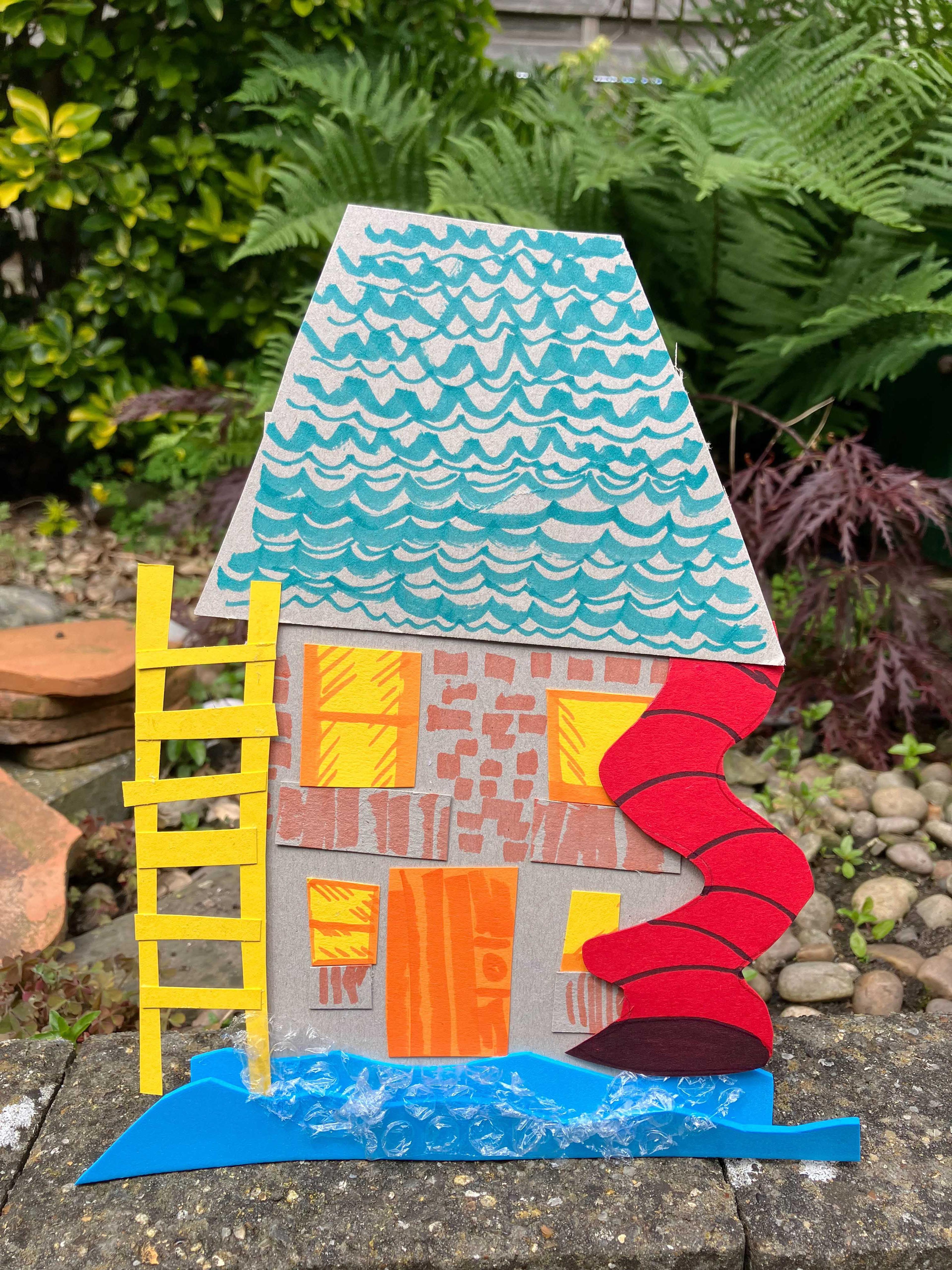 A collaged house made with paper and card