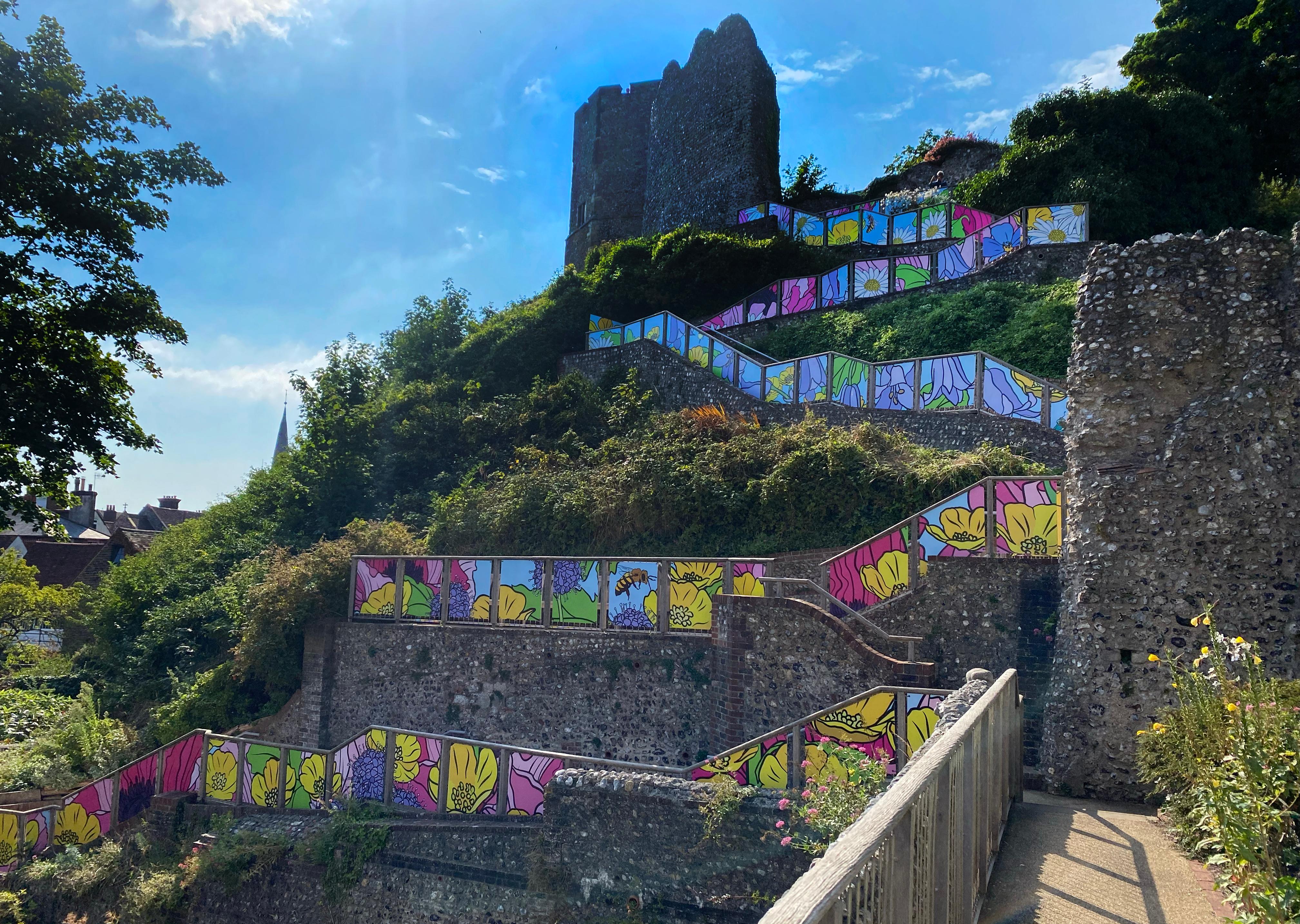 Colourful panels can be viewed on a large hill, with a castle at the top. 