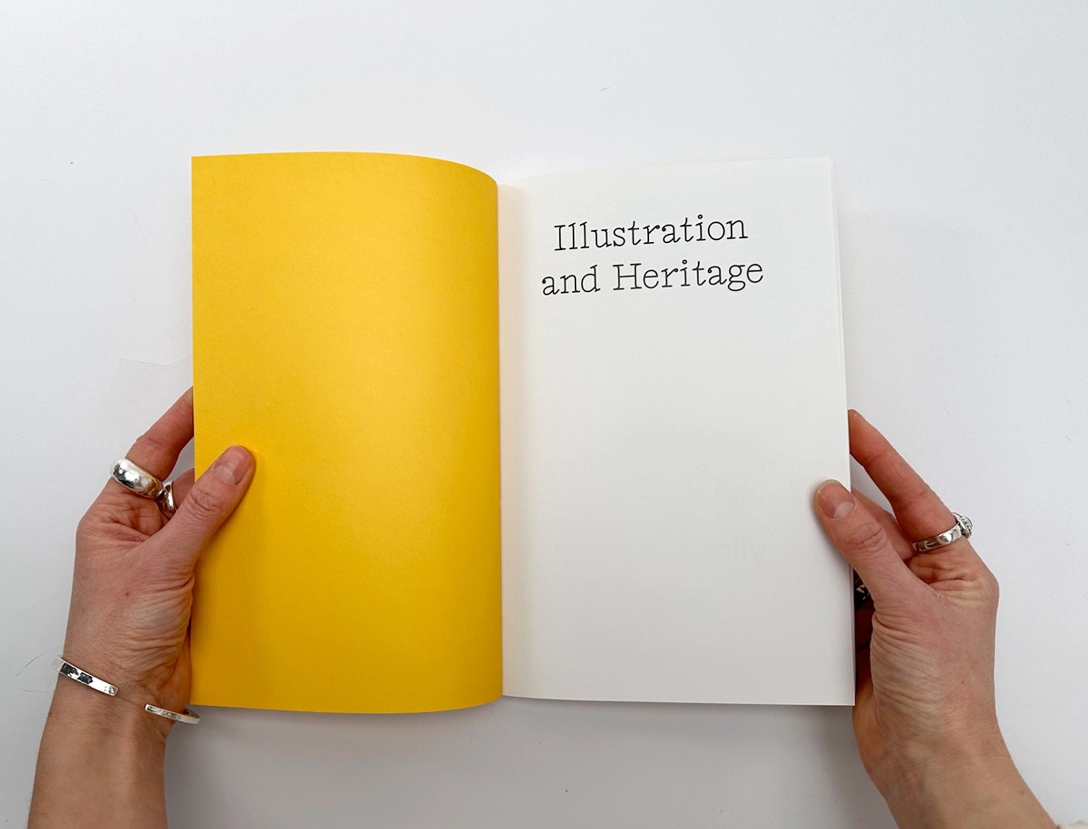 Photograph of two hands opening up a copy of the Illustration and Heritage book.