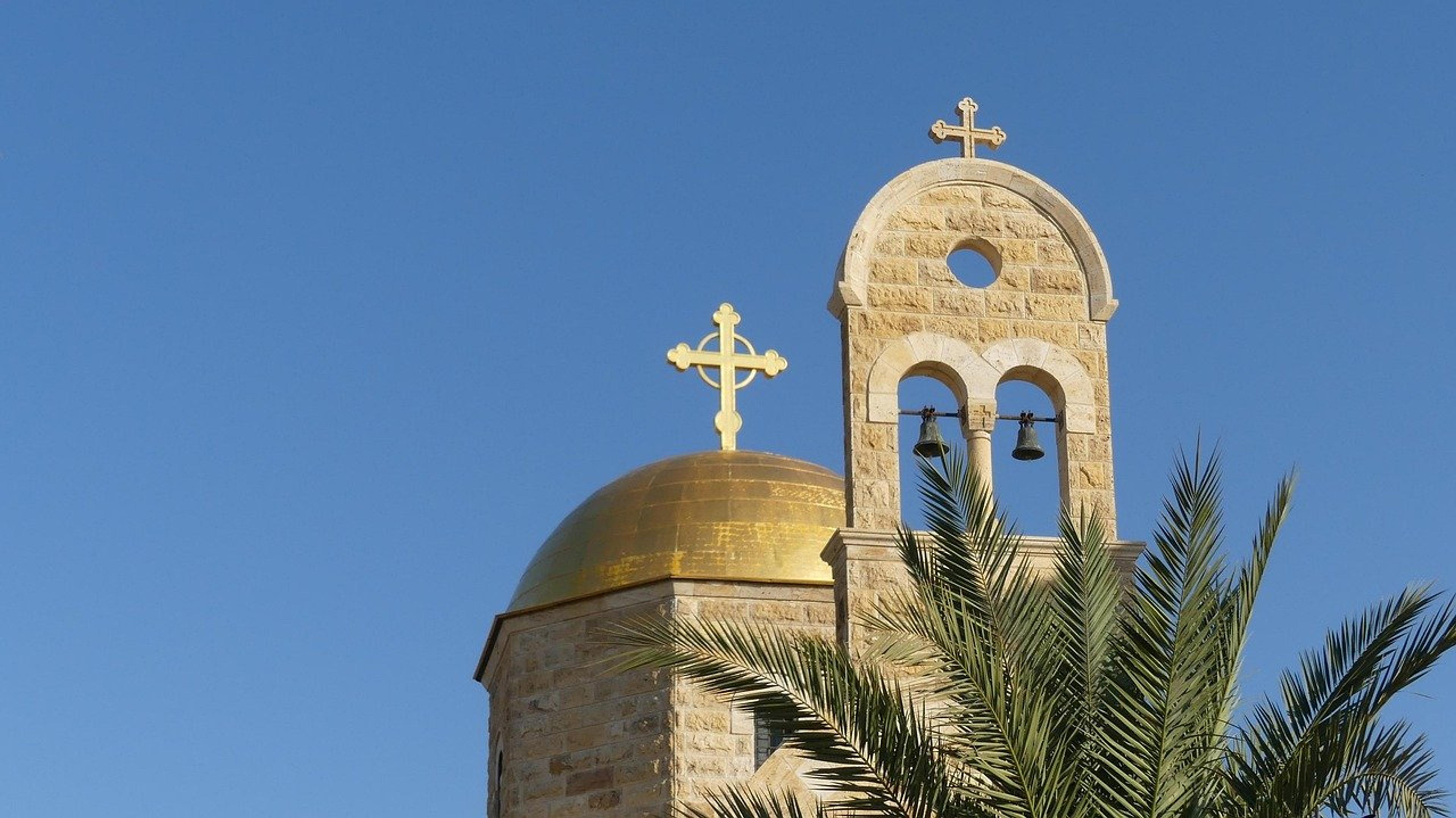 Church bell tower and golden dome with crosses in Jordan