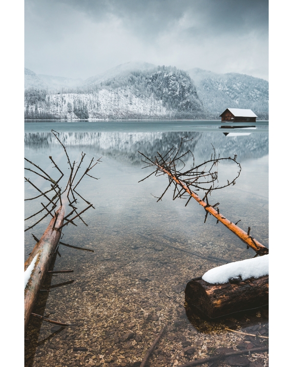 Snowy mountains reflected in calm winter lake