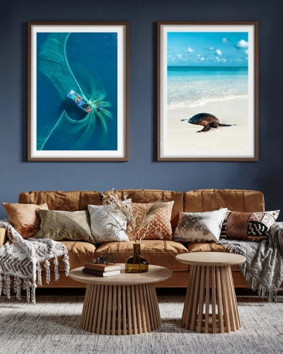 Two framed posters hanged in the living room over and orange soffa