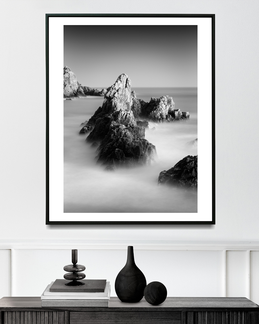 A poster of a Black-and-white rocky coastline with misty ocean waves