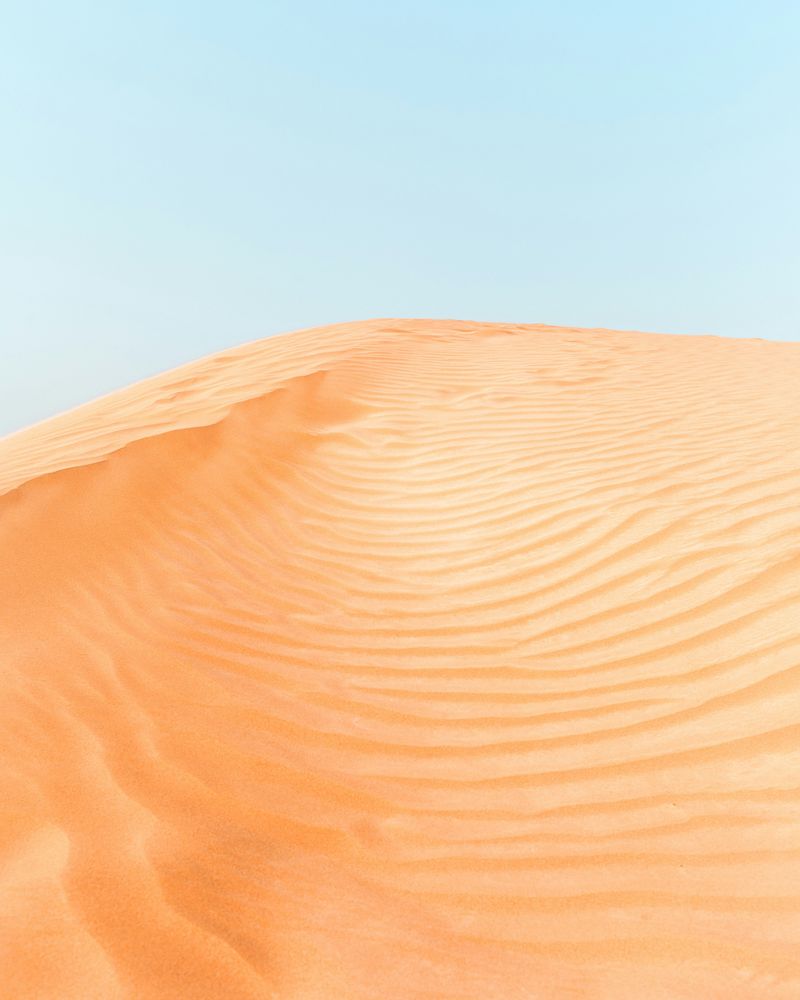 An orange desert with a blue sky poster