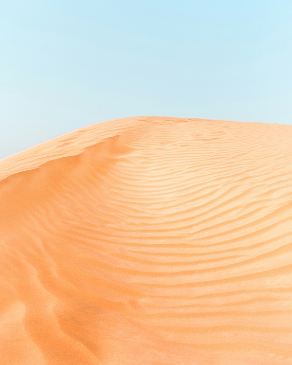 An orange desert with a blue sky poster