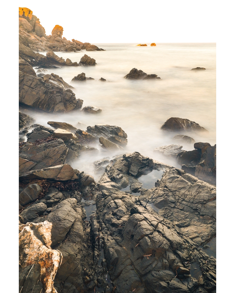Rocky coastline with misty water and soft light