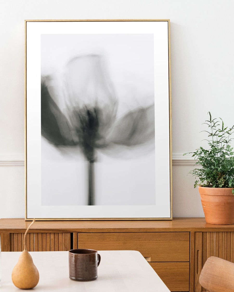 Blurred Tulip Study poster in a slim gold frame leaning on a wooden sideboard in a bright dining room