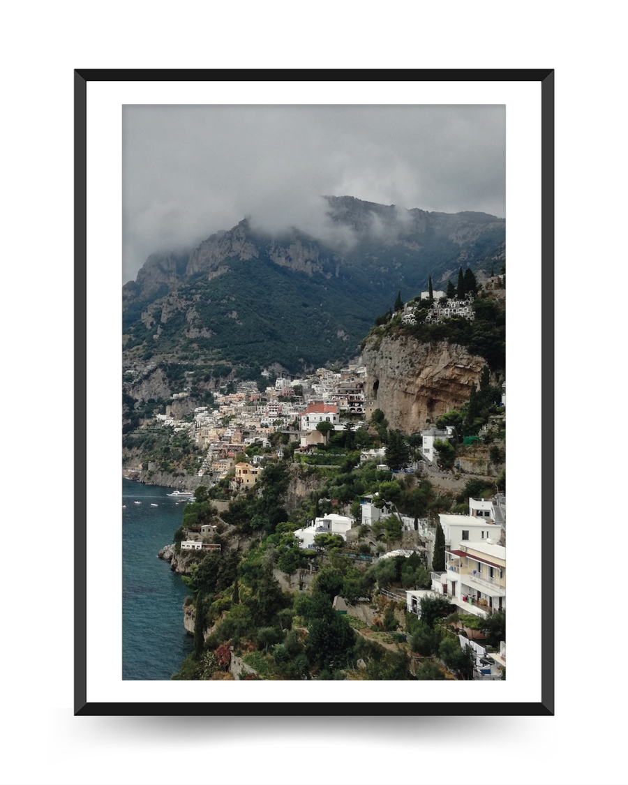 A poster of a Cliffside coastal town overlooking deep blue sea