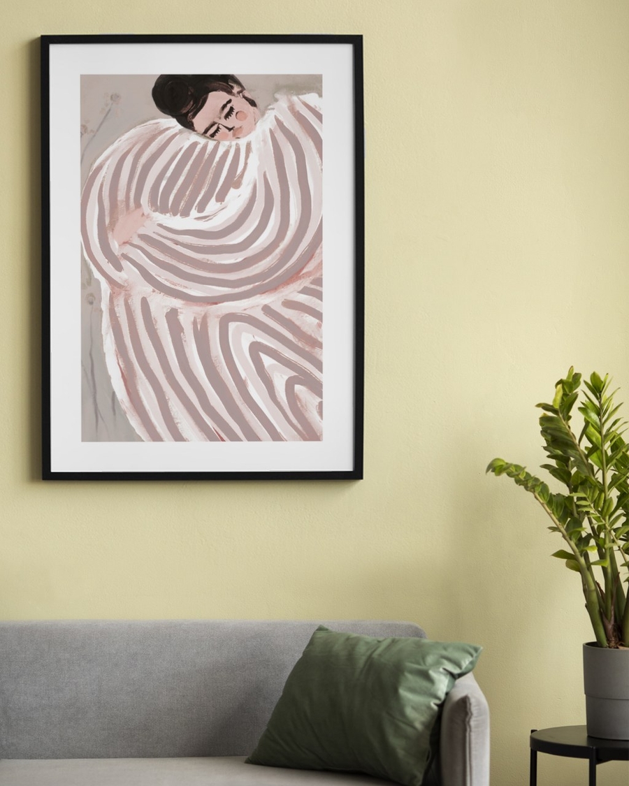 Resting in Stripes poster in a slim black frame on a soft yellow wall above a grey sofa