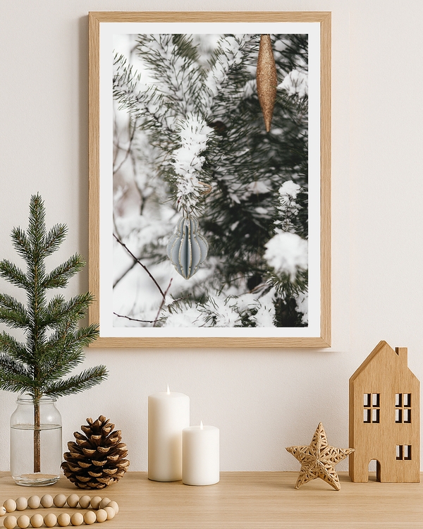 A poster of a snow-covered pine branches with elegant Christmas ornaments