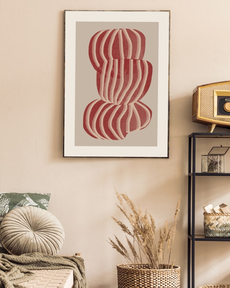Ruby Stripe Stack poster in a slim dark frame on a beige wall above a woven chair and dried grasses