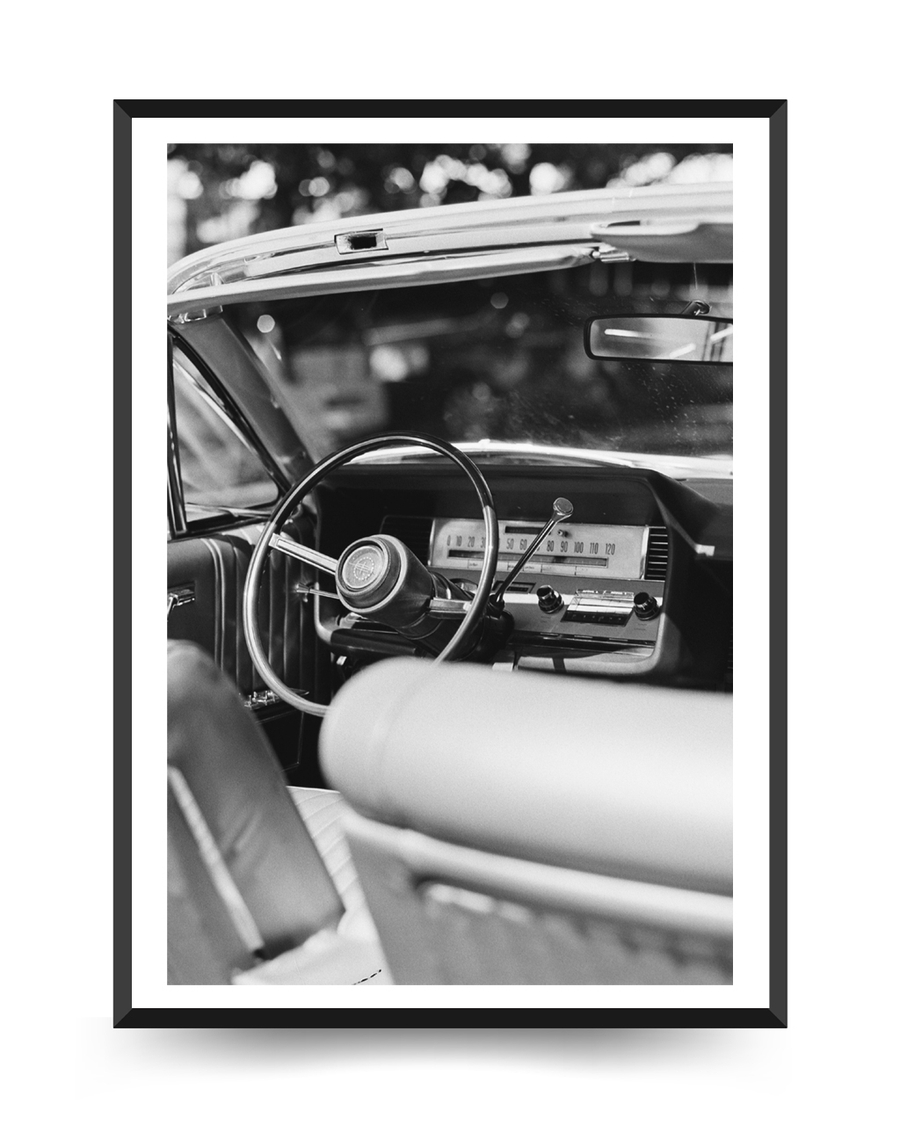 A poster of a Black and white vintage car interior from driver seat