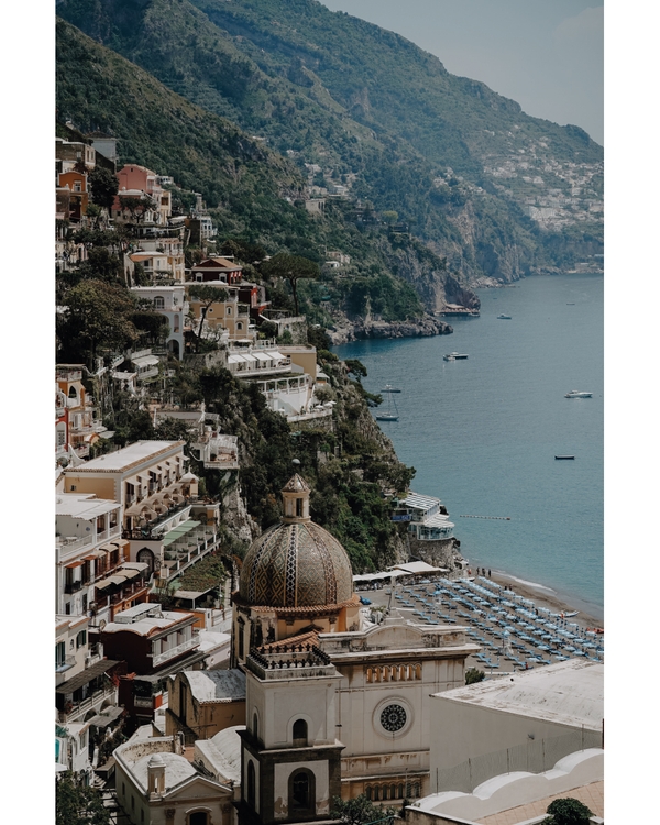 Historic coastal city with domed building by sea