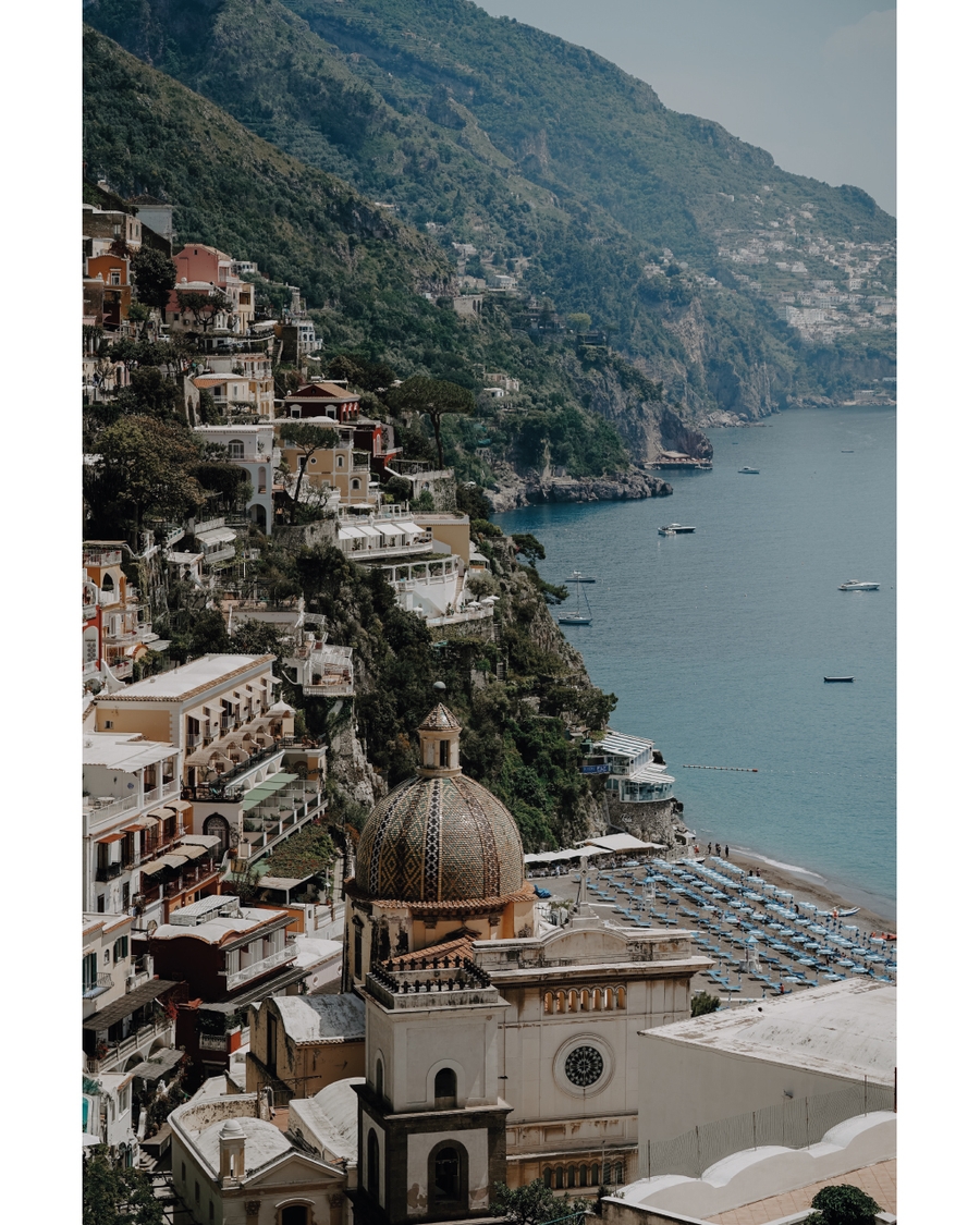 Historic coastal city with domed building by sea