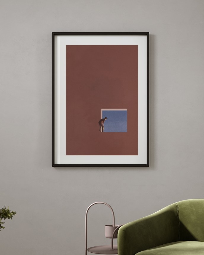 Window to Blue poster in a slim black frame on a grey wall above a green velvet armchair