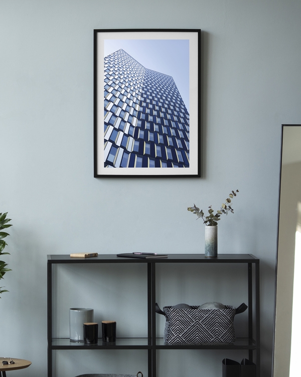 A poster of a tall modern building with geometric patterned windows