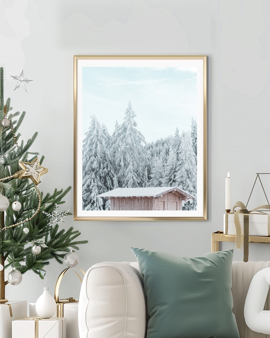 A poster of a snow covered pine trees behind a wooden cabin