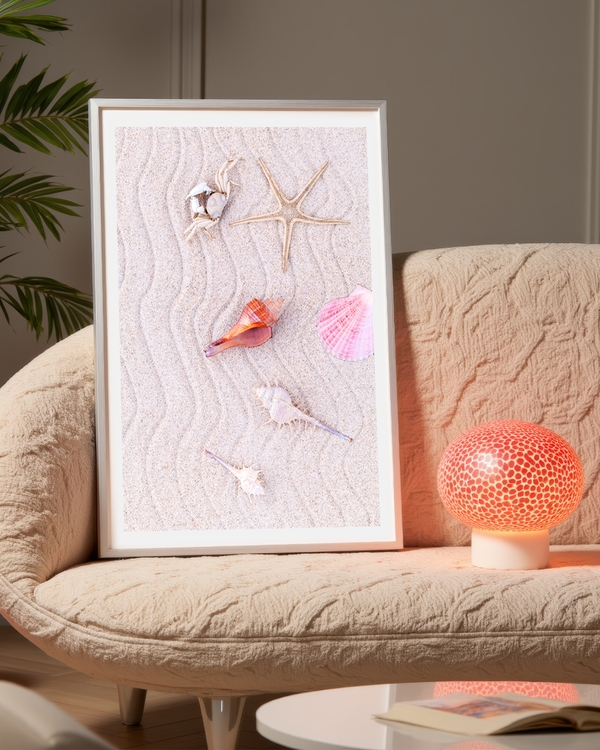 A poster of a Seashells and starfish arranged on soft beach sand