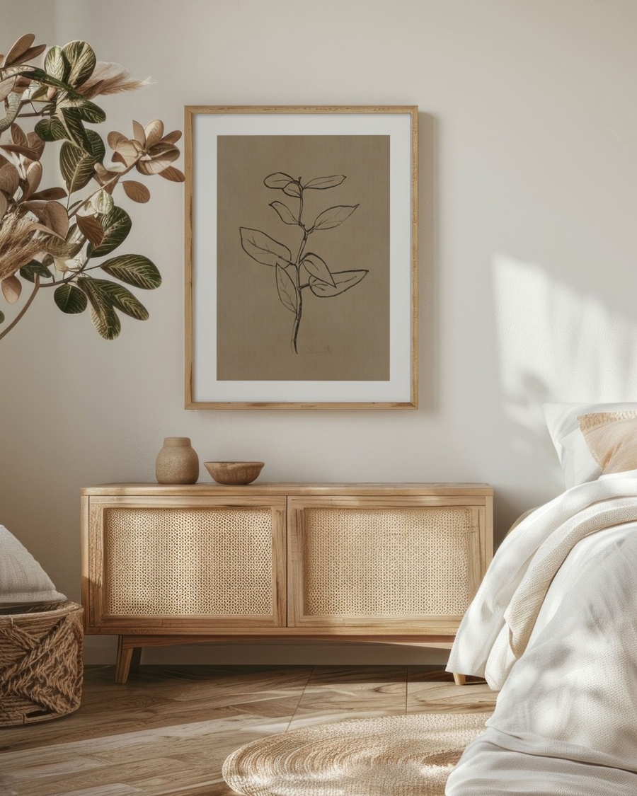 Charcoal Sprig poster in a light oak frame above a rattan sideboard in a boho bedroom