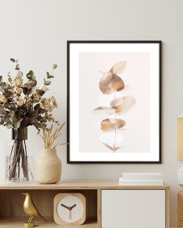 Gilded Eucalyptus poster in a slim black frame above a wooden sideboard with dried flowers