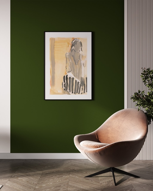 Woman in Warm Light poster in a slim black frame on a deep green wall above a leather lounge chair