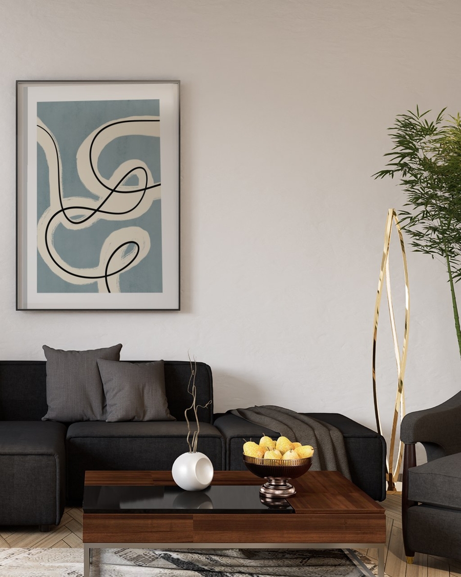 Ribbon and Ink poster in a slim black frame above a dark grey sofa in a modern living room