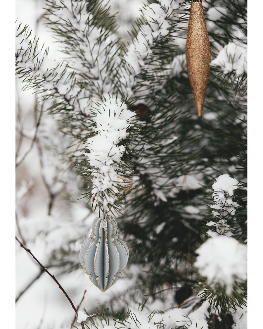 Snow-covered pine branches with elegant Christmas ornaments