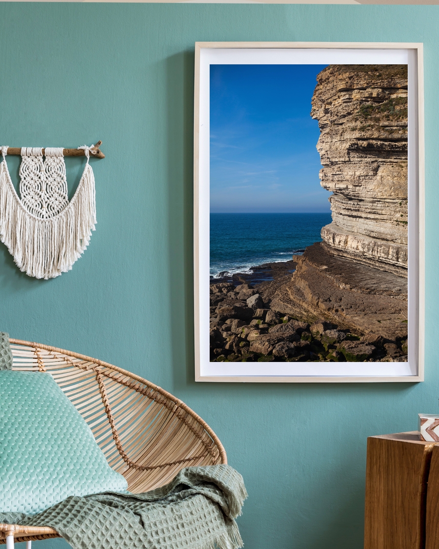 A poster of a Layered rocky cliff by deep blue ocean waves