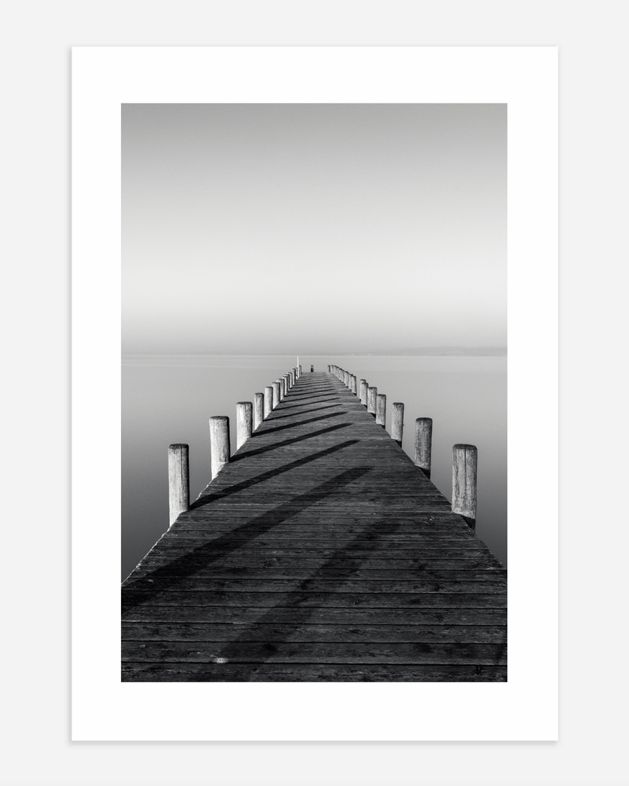 A poster of a Symmetrical wooden pier leading into calm water