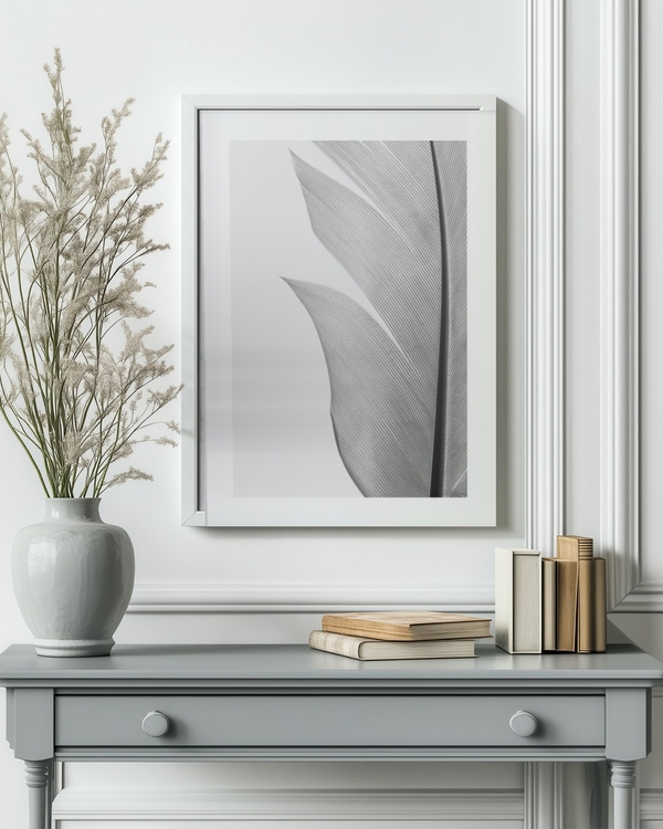 Silver Quill poster in a white frame above a grey console table in a bright hallway