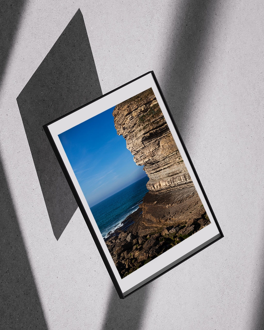 A poster of a Layered rocky cliff by deep blue ocean waves