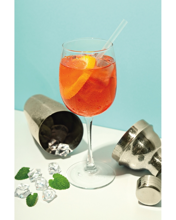 Orange cocktail with ice cubes and citrus peel