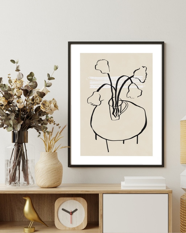 Flowers in a Mug poster in a slim black frame above a wooden sideboard with dried flowers