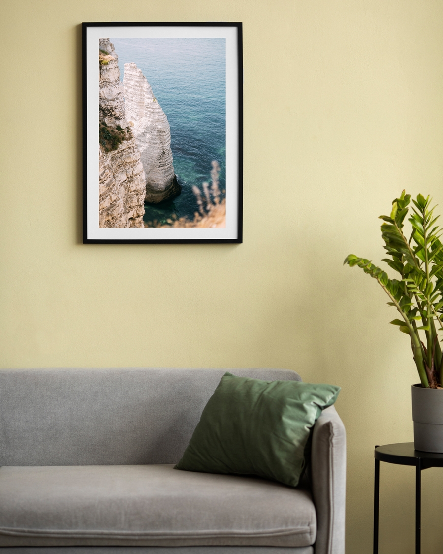 A framed poster of a coastal with white cliff and blue water