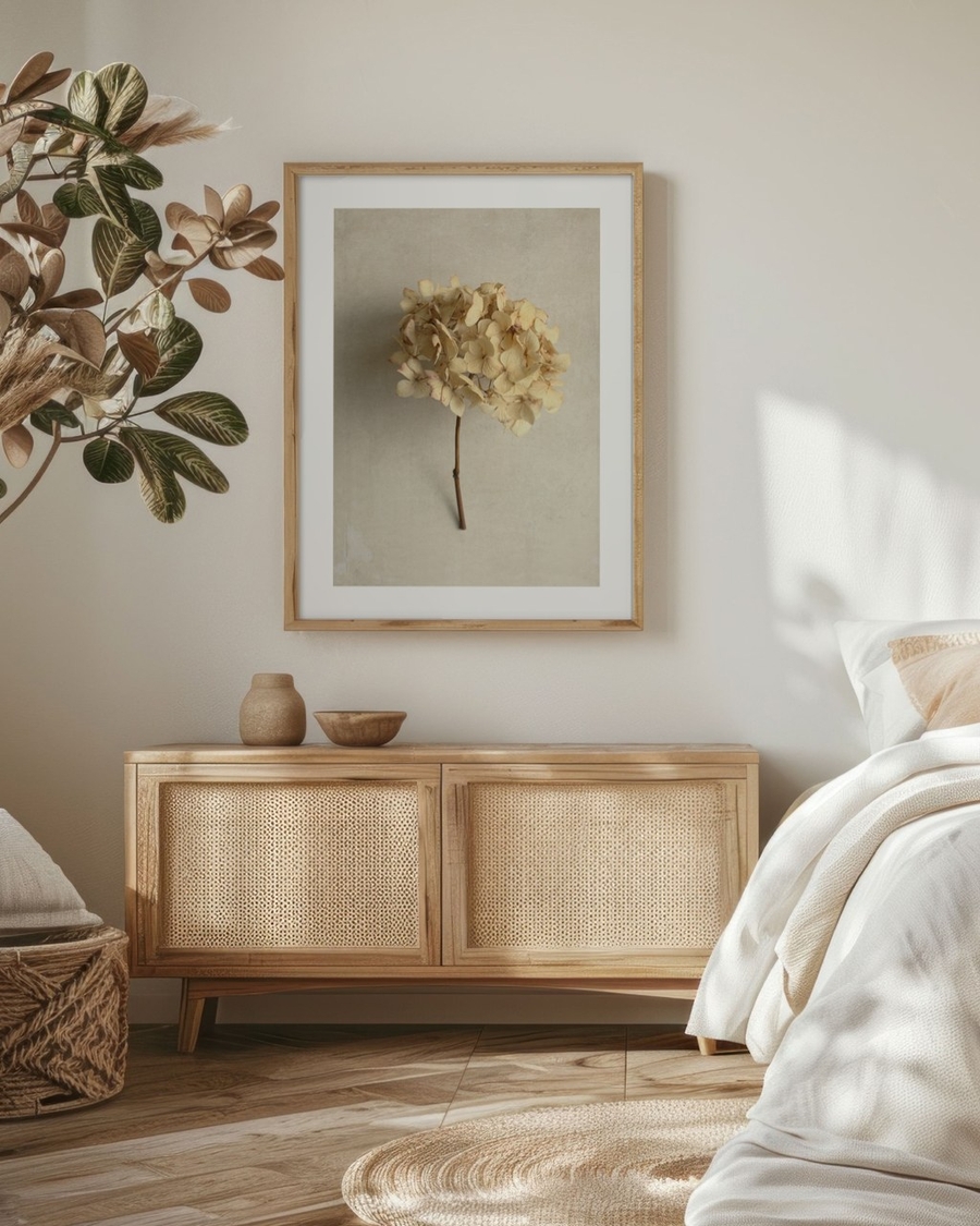 Dried Hydrangea Stem poster in a light oak frame above a rattan sideboard in a boho bedroom