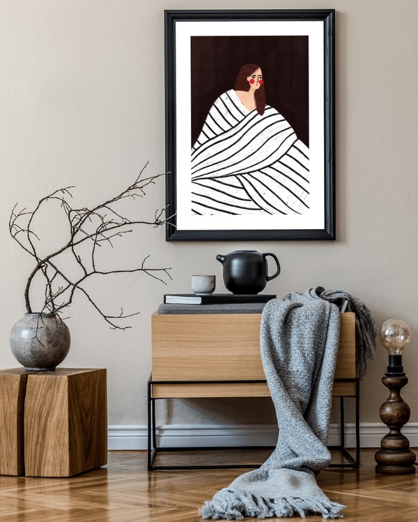 Wrapped in Stripes poster in a black frame above a wooden sideboard in a calm neutral hallway
