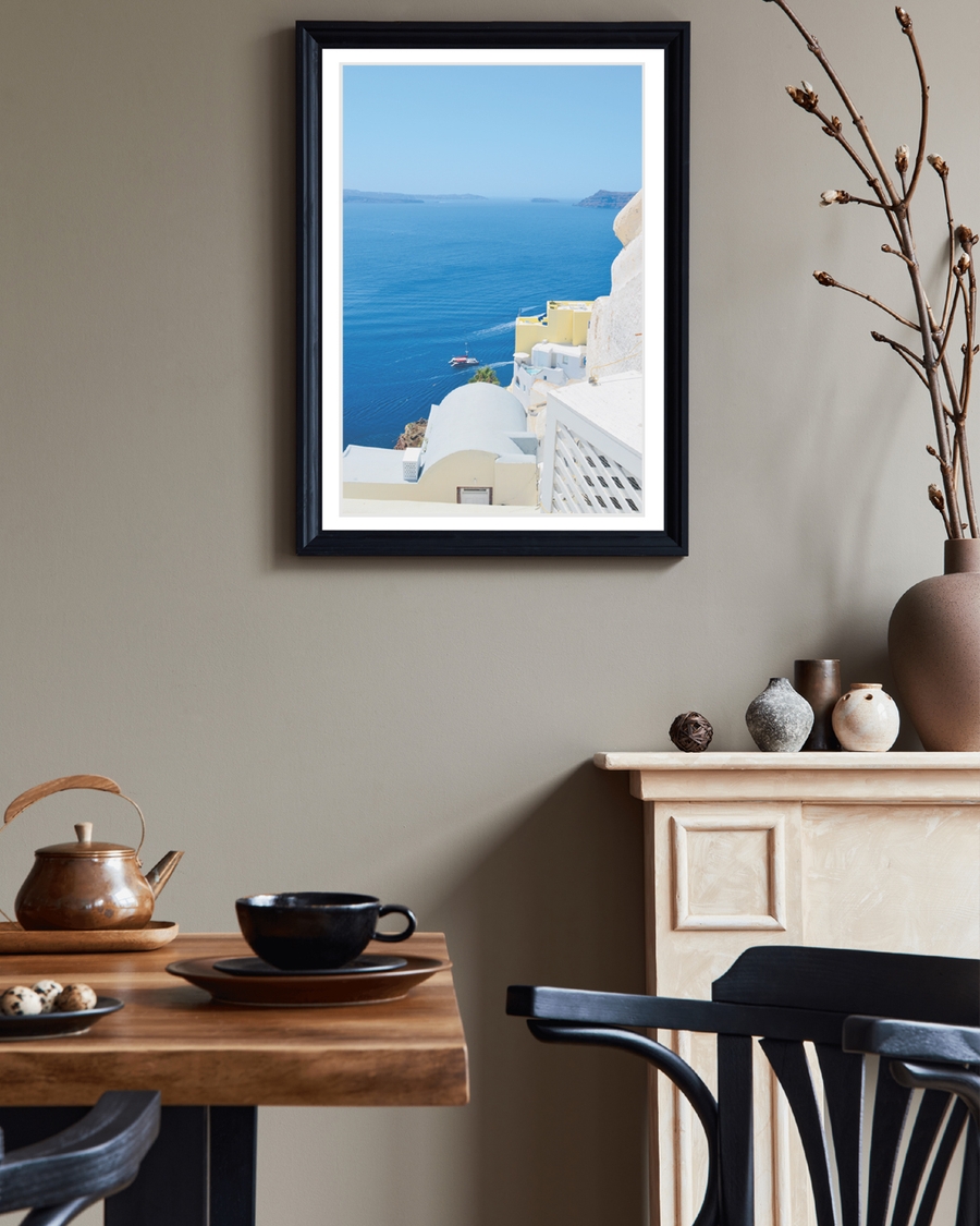 A poster of a White coastal buildings overlooking deep blue sea