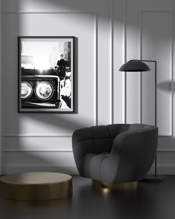 A poster of a Close-up of classic car headlights with blurred city background.