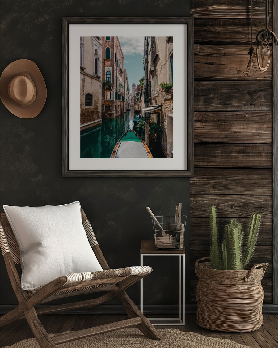 Venetian Waterway poster in a dark wooden frame on a black wall above a rattan chair