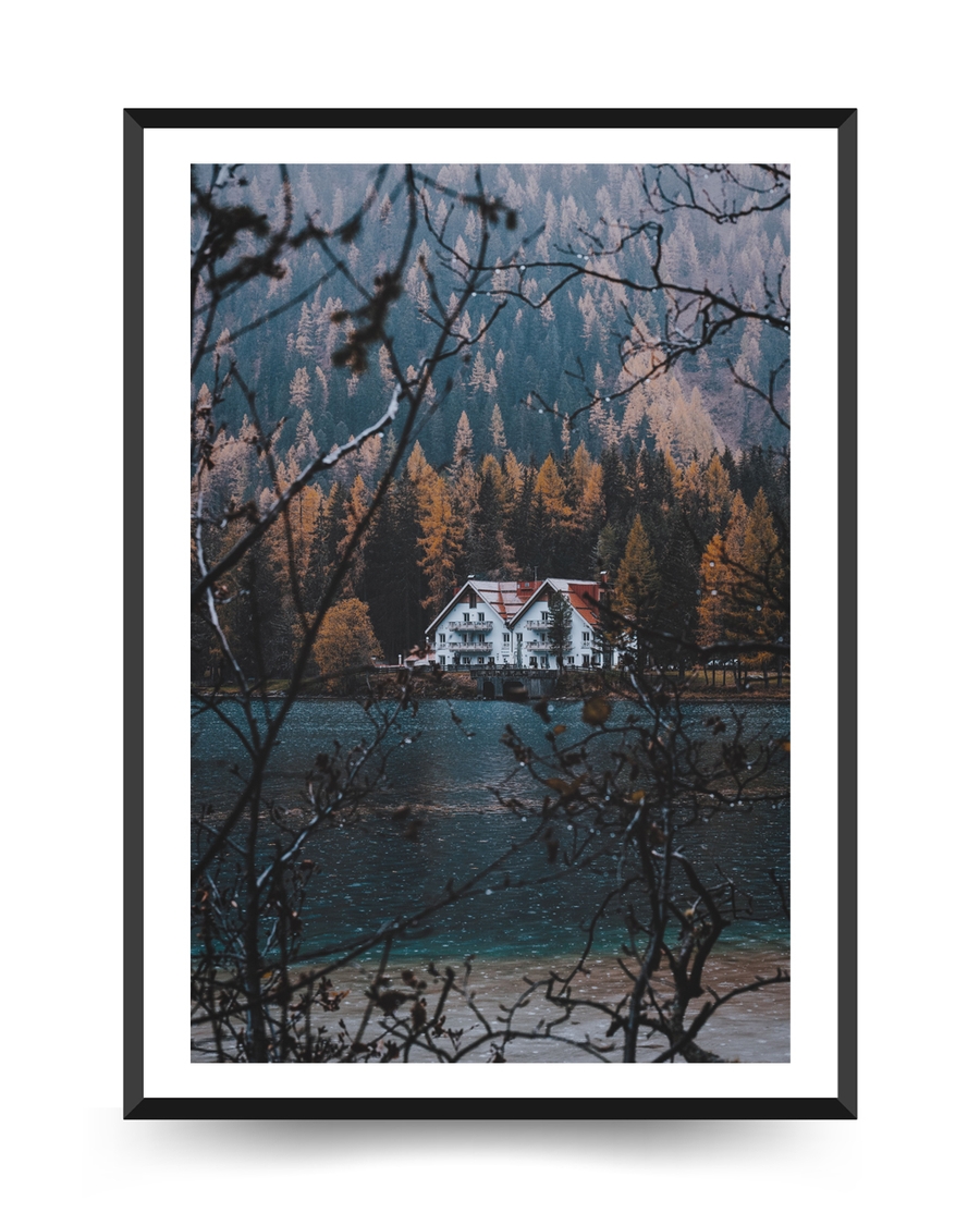 A poster of a White house by lake surrounded by autumn forest