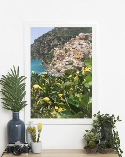 A poster of a Colorful hillside village by turquoise sea and greenery