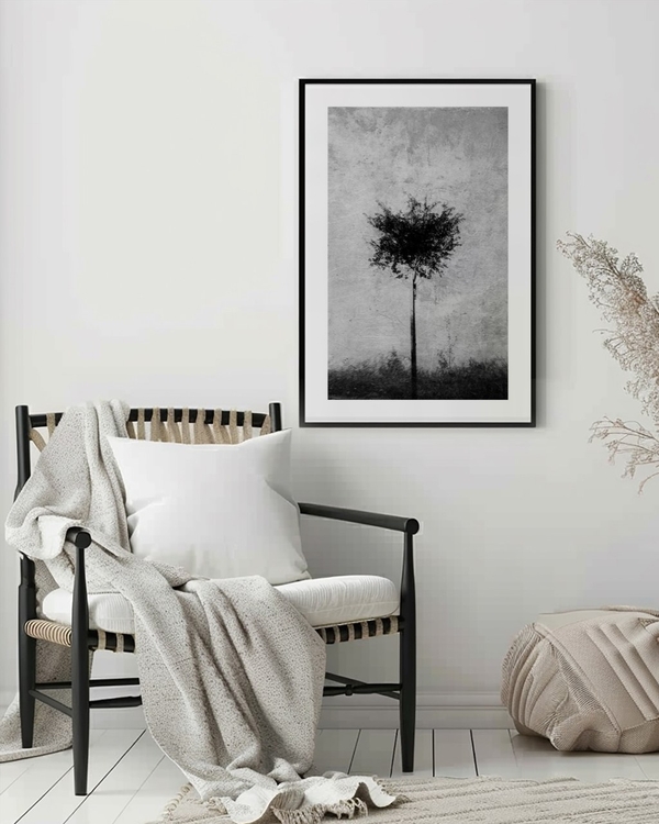 Silver Grain Tree poster in a slim black frame above a black wooden armchair in a bright minimal room
