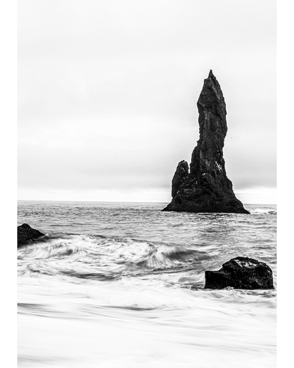 Tall sea stack in monochrome ocean view
