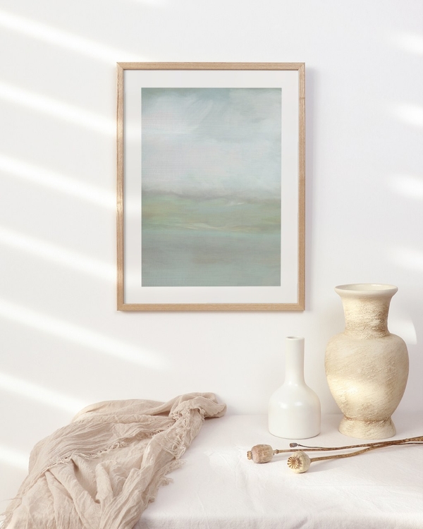 Pale Meadow Mist poster in a light oak frame above a draped table with ceramic vases