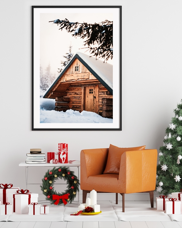 A poster of a cozy wooden cabin surrounded by snowy winter trees