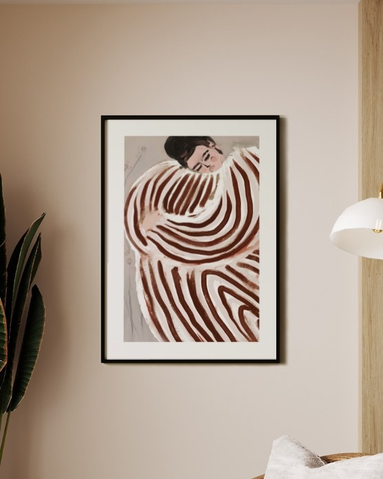 Dreaming in Rust poster in a slim black frame above a wooden armchair in a bright corner