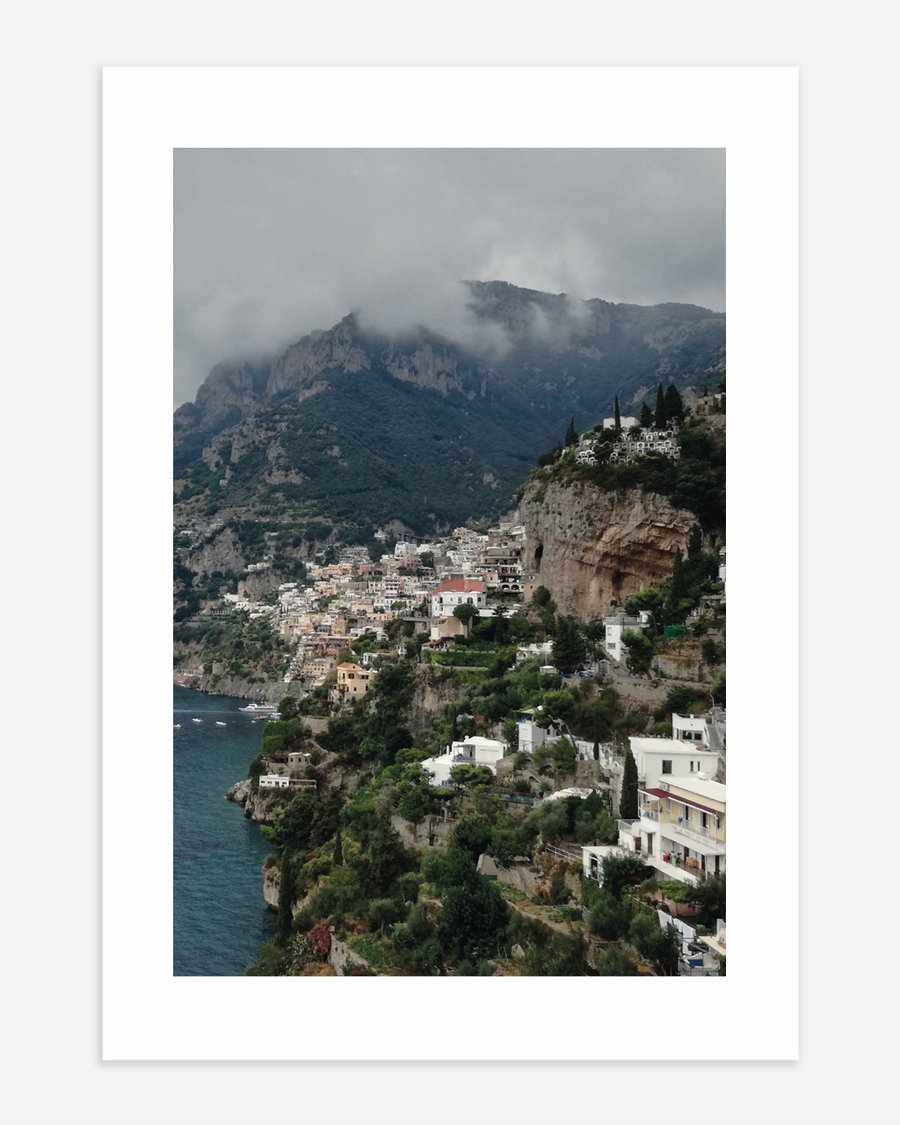 A poster of a Cliffside coastal town overlooking deep blue sea
