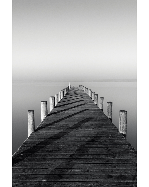 Symmetrical wooden pier leading into calm water
