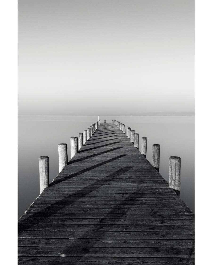 Symmetrical wooden pier leading into calm water
